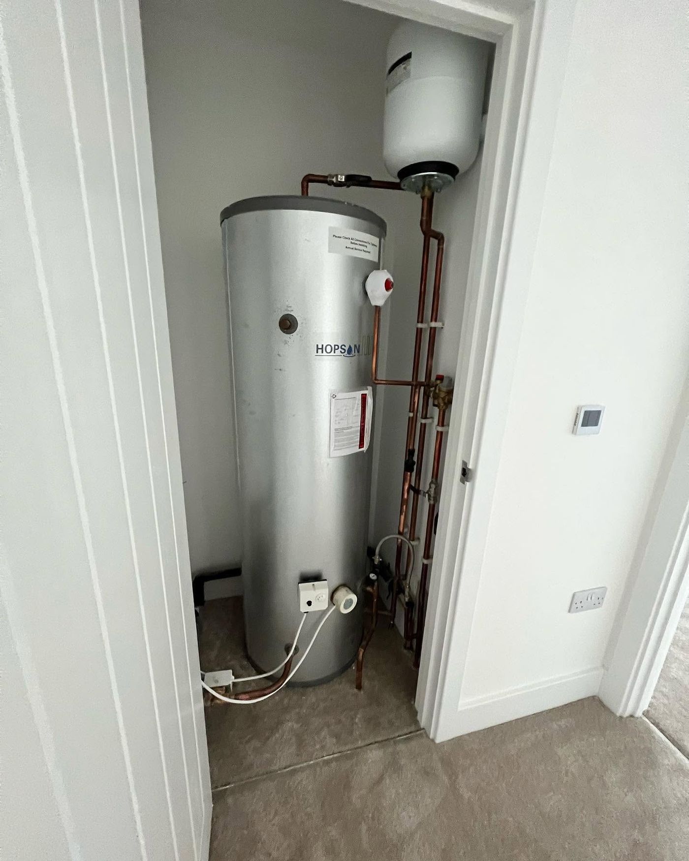 New unvented hot water cylinder in an airing cupboard